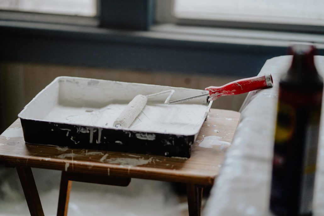 Rouleau à peinture blanche représentant les travaux d'un logement