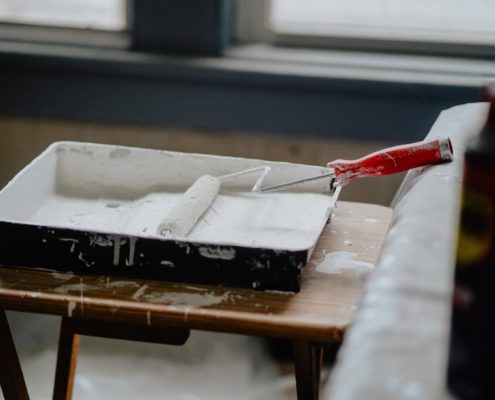 Rouleau à peinture blanche représentant les travaux d'un logement