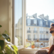 Homme heureux, devant une fenêtre devant des immeubles à Paris